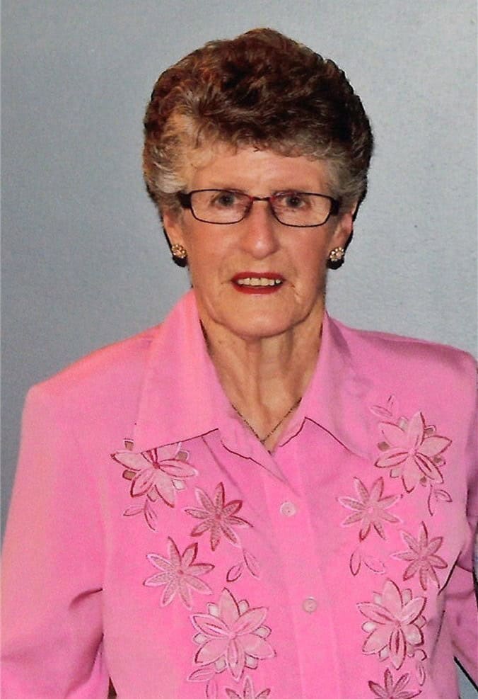 Smiling person in pink floral shirt.