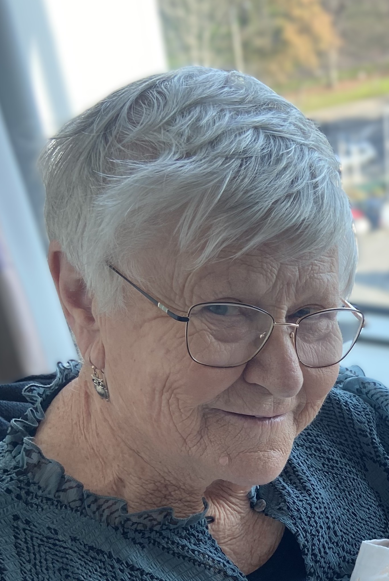 Elderly woman smiling indoors.