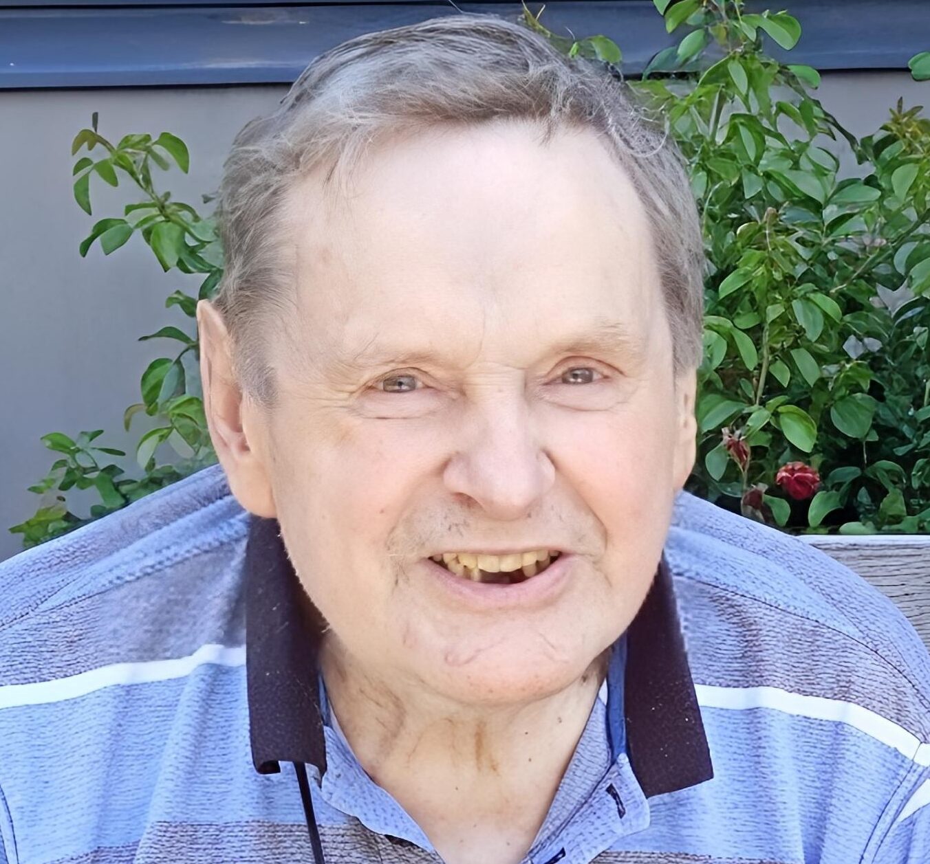 Smiling elderly man in striped shirt outdoors